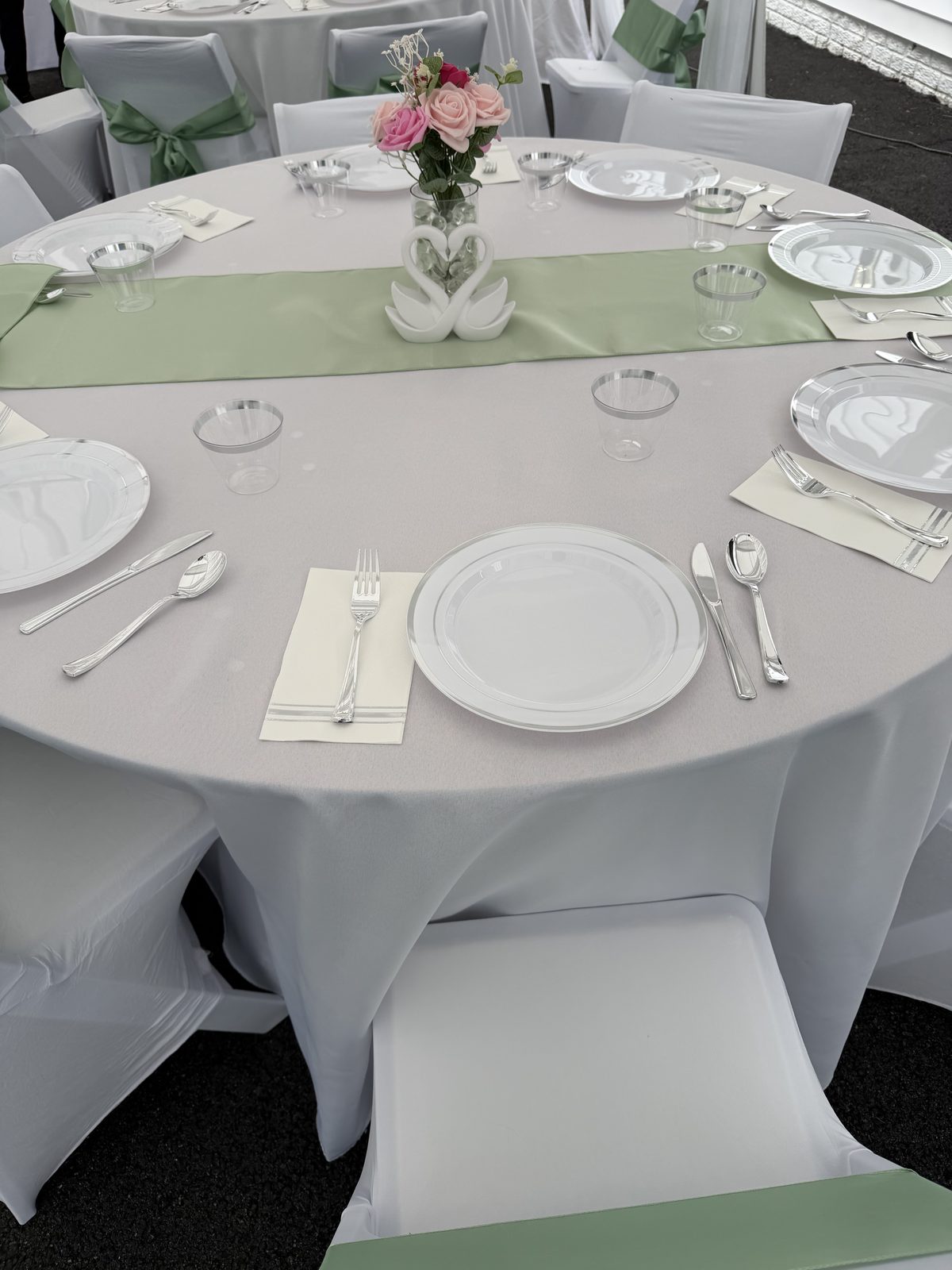 Close-up of a table place setting with plate, flatware, and floral centerpiece